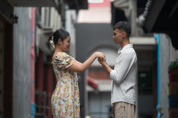 Obraz premium Young Asian Couple enjoying and walking holding hands at street