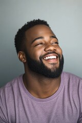Obraz premium African American Man With Beard. Confident Young Man in Casual Purple T-shirt Laughing and Looking Away with Natural Expression