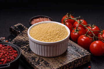 Wheat porridge couscous grains on a dark concrete background