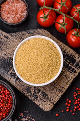 Wheat porridge couscous grains on a dark concrete background
