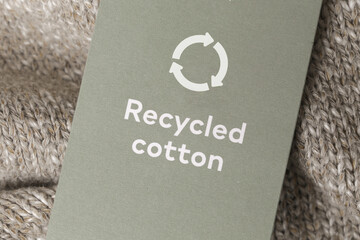 Close up of clothing tag with recycle icon. Recycling products concept. Zero waste, suistainale production, environment care and reuse concept.	