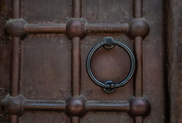 Close-up of an antique metal door with a vintage iron knocker