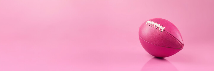 Minimalist image of pink football ball on pink background, solid color background for website banner.