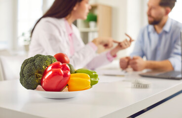 Vegetable healthy plate close up, fresh broccoli, red, green pepper at dietary consultant desk....