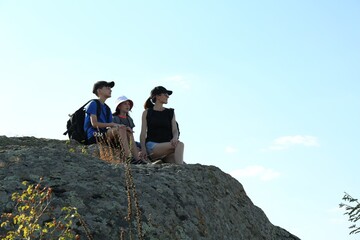 Cute family enjoying picturesque landscape on stone