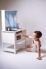 Child plays at cooking in playroom with wooden toys. Symbolic play, cognitive development