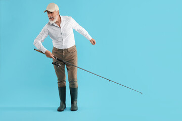 Fisherman with rod on light blue background