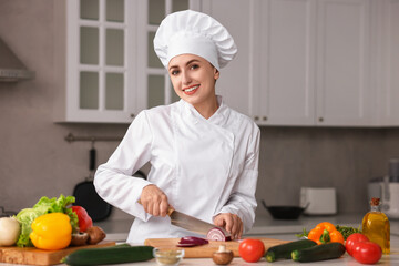 Professional chef cutting onion at table in kitchen