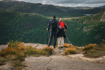 Turistas o senderistas de montaña mirando el paisaje de Preikestolen, o Púlpito,  gran roca que se levanta sobre el fiordo lysefjord en Noruega.