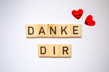 Danke thank you card in german language, Germany, readable letters on wooden blocks and off white background and two gloss red hearts