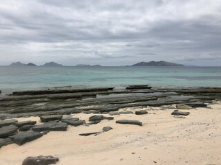 Empty South Seas beach on cloudy day with islands