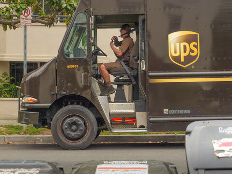 LOS ANGELES, CA - May 2024: UPS delivery truck delivering packages to a building on a residential street in city of West Hollywood, California