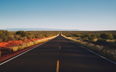 Obraz premium Australian Outback Road with Space for Text Under a Clear Blue Sky