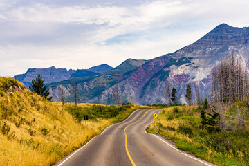 Scenic Road Through Waterton Alberta Canada With Majestic Mountain Views And Lush Green Landscape