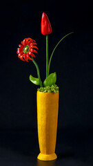 Flower arrangement of sweet peppers and zucchini.