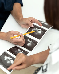 Doctor and patient discuss ultrasound results. Diagnosis of disease using ultrasound images. doctor...