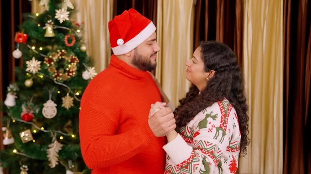Indian Couple Doing Romatic Dance with Christmas Tree in background