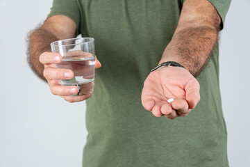 Fototapeta premium Close up of senior man taking medicines with water