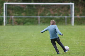 jeune garçon en train de tirer au football, loisirs et sport