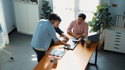 Group of diverse people sharing idea while writing at sticky notes. Professional smart business team brainstorming idea and planning strategy for startup project while wear casual outfit. Convocation.