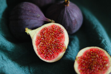Close up of fresh ripe fig fruits in green fabric with dark shadows