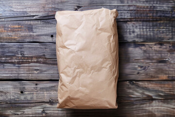 Obraz premium Crumpled Brown Paper Package on Rustic Wooden Surface for Mockup or Packaging Design