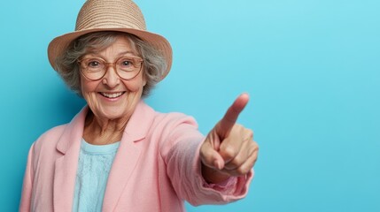 This is a funny picture of an old senior woman or grandma wearing a pink shirt, smiling and pointing at the camera. She has glasses and is funny. She looks like an old retired pensioner with gray