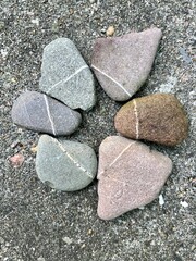 pebbles with a white line lie decorated in a row so that the line is continuous