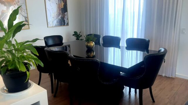 interior de sala de estar com mesa preta e tour pela cozinha com ilha moderna de quartzo branco