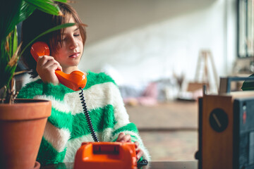 retro, cute girl teen talking on old orange vintage phone with dialer