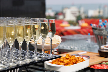 Outdoor Wedding or elegant party buffet table with fruity, sweet and salty appetizer little cake and bites with champagne