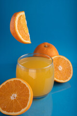 photo, glass, orange, juice, citrus, whole, half, photography, composition, bright, blue, background, around, midair, nutritious, detailed, image, colorful, healthy, fresh, fruit