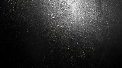 Obraz premium Close-up of water droplets on a dark surface, creating a dramatic and textured visual effect.