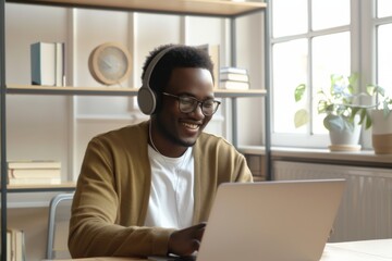 Happy millennial man in glasses enjoying an educational webinar on his laptop in a cozy modern workspace