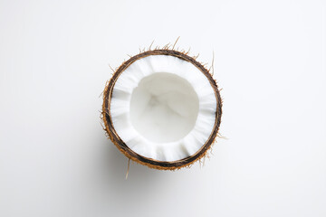 Top view of a half coconut on a white background, ideal for health and nutrition themes.