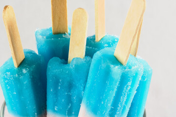 Frozen blue popsicles for fourth of july on stick closeup.