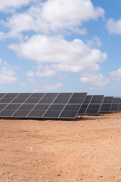 Solar panels spread across a desert landscape