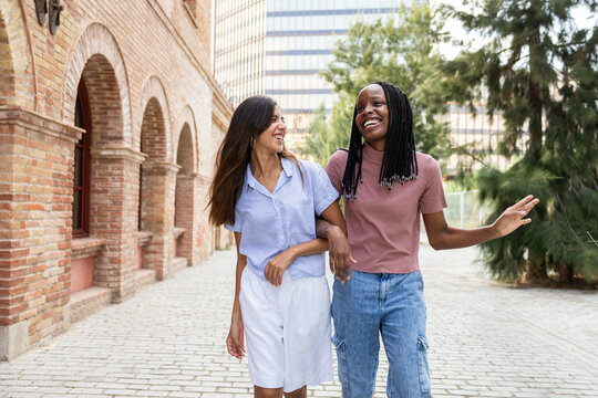 Two joyful students walking on a university campus