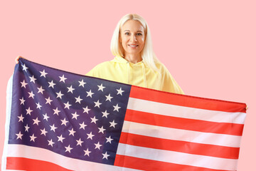 Mature woman with USA flag on pink background