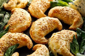 Spinach and blue cheese pastries, patty cakes made from puff pastry, focus on pastry in the center, close-up