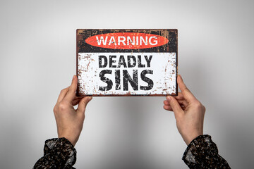Deadly Sins. Warning sign with text on a white background