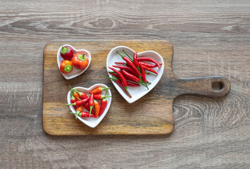 red chili pepper fresh on a white plate in the form of a heart on the board