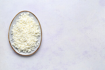 Plate with fresh cottage cheese on grey table