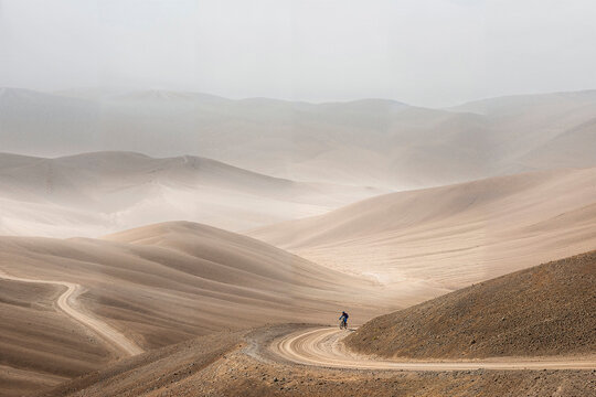 Cyclist winding through vast, serene desert landscapes