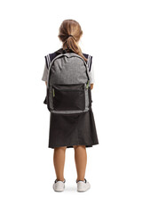 Rear view shot of a schoolgirl in a uniform carrying a backpack