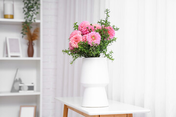 Fototapeta premium Vase of beautiful pink dahlias on table in living room
