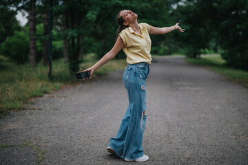 Young girl having fun alone in the park while holding a smart phone, feeling free and joyful