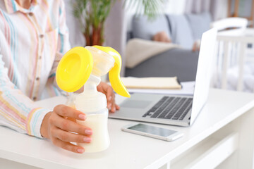 Working mother with breast pump at home, closeup