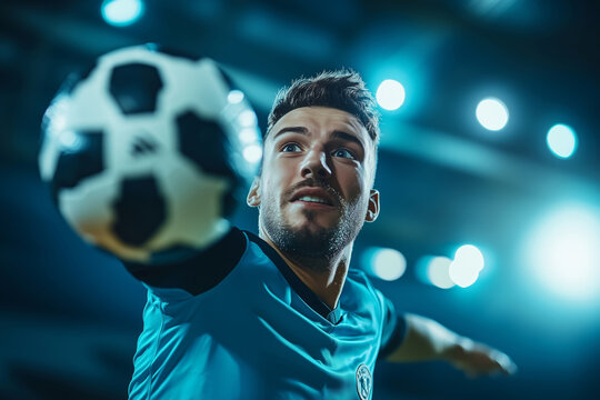 Indoor soccer player performs a throw-in during a competitive match under bright stadium lights