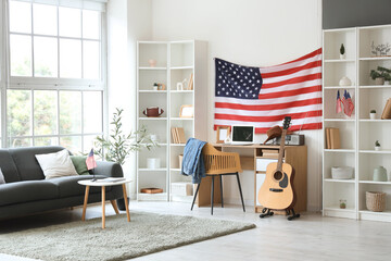 Interior of living room with USA flag, grey sofa and comfortable workspace